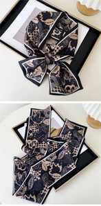 Detail of floral and checkerboard print on a long narrow silk scarf for women