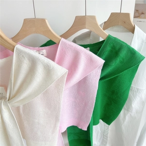 Gestrickter Schal mit Schleifenstruktur in Creme, Rosa und Grün auf Holzbügeln