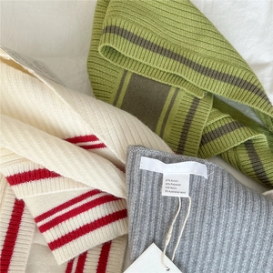 Detailed view of striped knitted shawl material with 3% Australian wool fabric label