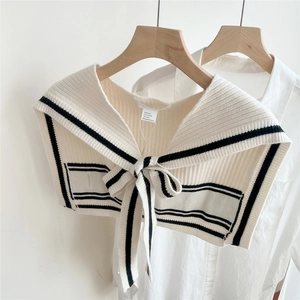 Detail of the knit texture and striped bow-tie design on the cream knitted shawl