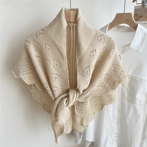 Close-up of knit shawl with heart-shaped cutouts and scalloped edges on a shirt