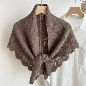 Detail of dark brown knitted shawl featuring delicate hollow patterns and scalloped edges