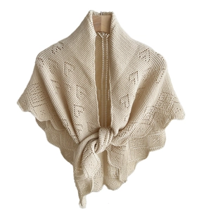 Knitted cream shawl with openwork pattern and scalloped edges tied at the front