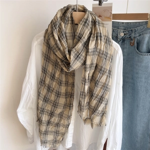 Detail of beige plaid cotton linen scarf with crinkle texture and fringe edges