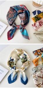 Close-up of elegant floral silk scarves in navy and cream with smooth satin texture
