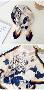 Floral champagne silk scarf detail with bird and dragonfly motifs on ivory table