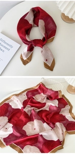 Close-up of abstract floral silk scarf with burgundy and cream tones and gold hem