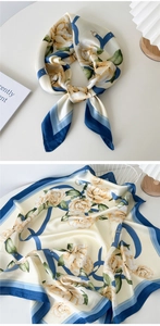 Detail of silk scarf showing yellow roses and blue belt pattern on smooth fabric
