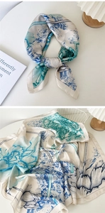 Detail of silk scarf with blue floral print and architectural pattern on white background
