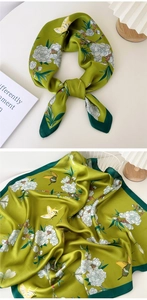 Detail of silk scarf featuring elegant floral patterns and butterflies in green
