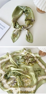 Detail of light green floral silk scarf featuring classic peony patterns and satin texture