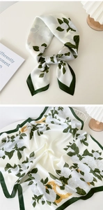 Detail of silk scarf showing floral rose pattern with green border and chain print