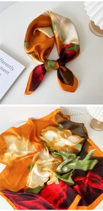 Detail of silk scarf with orange flower patterns and elegant machine-stitched edges