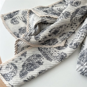 Vue détaillée du motif paisley plissé et de la texture en lin sur cette longue écharpe