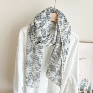 Détail d'une écharpe froissée à motif paisley drapée sur un cintre en bois chic