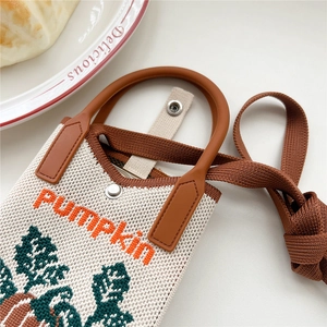 Detail der gestrickten Handytasche mit Kürbismuster, orangem Text und Metalldruckknopf
