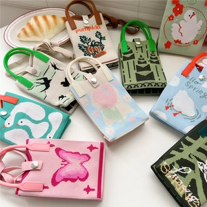 Vielfalt an gestrickten Handytaschen mit bunten Cartoon-Mustern und Druckknopfverschluss
