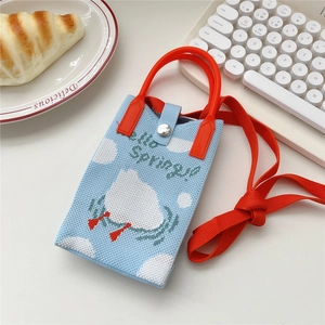 Makroaufnahme der gestrickten Mini-Handytasche mit Hello Spring Stickerei und Druckknopf