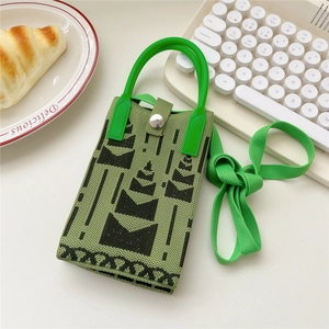 Detail der grünen gestrickten Handy-Mini-Tasche mit Bergmuster und Metalldruckknopf
