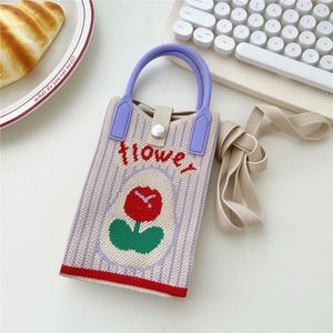 Detail der gestrickten Handytasche mit Tulpenmuster, Flower-Text und lila Griff
