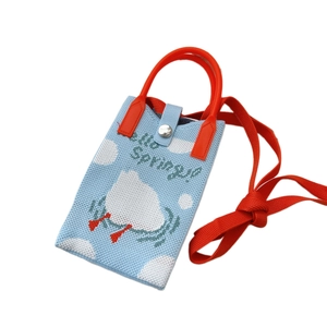 Blaue gestrickte Handytasche mit weißen Wolken und rotem Griff zum Umhängen und Tragen