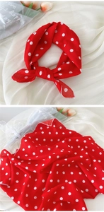 Détail de la texture du foulard en coton et lin à pois rouges avec fleurs décoratives
