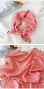 Détail d'un foulard en coton rose à pois bleus avec une décoration de tulipe