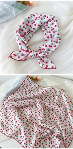 Détail du foulard en lin blanc avec imprimé cerise et bordure rouge cousue