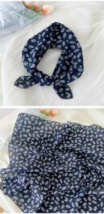 Détail d'un foulard en coton et lin bleu marine avec imprimés de feuilles et bord fin
