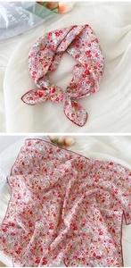 Détail d'un carré en coton lin floral avec bordure surjetée rouge et motifs de fleurs