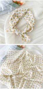 Gros plan d'un foulard léger en coton et lin avec d'élégants motifs de fleurs jaunes