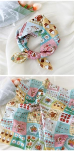 Détail d'un foulard en coton et lin avec des illustrations mignonnes de chats et de fleurs