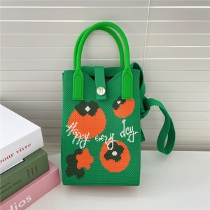 Détail du sac tricoté vert avec motif de kaki orange et bandoulière en maille de qualité