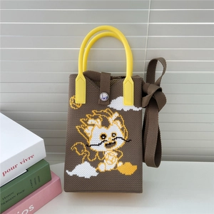 Détail du sac tricoté motif dragon avec art pixel et fermeture par bouton pression