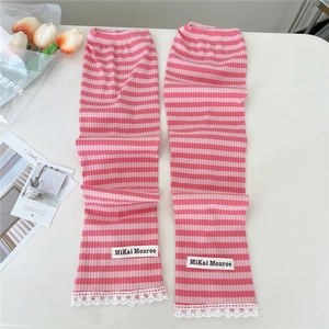 Detail of pink striped knit arm sleeves with delicate white lace trim and brand label