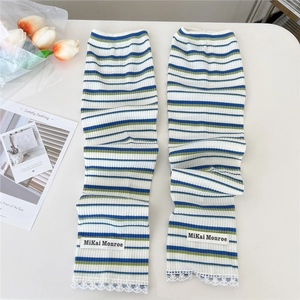 Detail of striped knitted arm sleeves with delicate lace trim and brand woven label