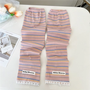 Detail of knit arm sleeves with pink stripes, white lace trim and logo label