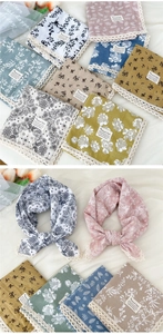 Dettaglio di foulard in cotone e lino con stampe floreali e bordi in pizzo