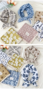 Dettaglio di foulard in cotone e lino con fantasie floreali e bordo in pizzo fine