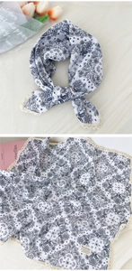 Dettaglio di sciarpa in cotone lino bianco con stampa paisley blu e bordo in pizzo