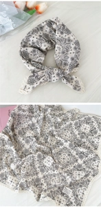 Dettaglio di sciarpa in cotone con stampa paisley ed eleganti bordi in pizzo color avorio