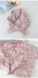 Dettaglio ravvicinato di sciarpa paisley rosa con bordi in pizzo bianco e morbido cotone fine