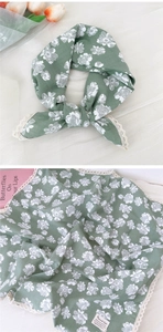 Dettaglio della sciarpa in cotone lino verde salvia con fiori e pizzo delicato