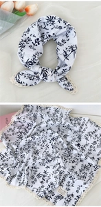 Dettaglio di un foulard quadrato a fiori con bordo in pizzo beige e tessuto in cotone