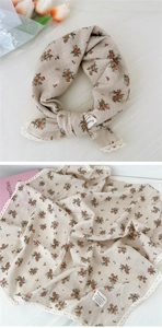 Dettaglio di sciarpa in cotone e lino beige a fiori con pizzo bianco ed etichetta chic
