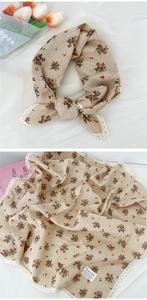 Dettaglio di un foulard in cotone lino a fiori con bordo in pizzo bianco all'uncinetto