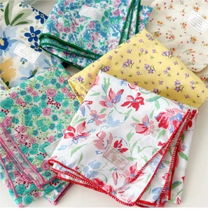 Flat lay of diverse floral cotton neckerchiefs with 100% cotton material stickers