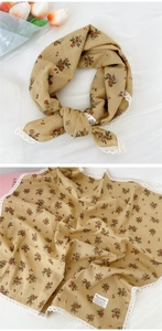 Dettaglio di foulard floreale in cotone e lino con bordo in pizzo bianco ed etichetta