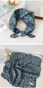 Detail of floral silk scarf with small blue flowers and black hemmed edge texture