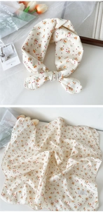 Close-up of cream cotton scarf featuring vintage floral print and fabric texture